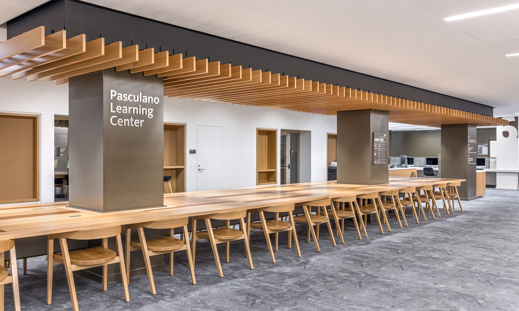 Photo of a long wooden table in the Pasculano Learning Center inside of the Stavros Niarchos Foundation Library (SNFL)